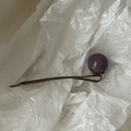 Détail d'une épingle à cheveux vintage en bronze avec perle mate violette sur papier - Violet