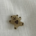 Vue détaillée d'une pince à cheveux ours en résine ambrée sur un tissu en lin blanc - Pince à Cheveux Café Transparent