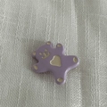 Dettaglio ravvicinato di un ciondolo a forma di orso viola con cuore dorato su tessuto - Fermaglio Per Capelli Viola