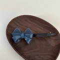 Detalle de un clip para el pelo con lazo azul 3D y letras doradas de France Handmade - Lazo de Gelatina Etiqueta Dorada-Azul Marino