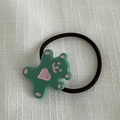 Détail d'élastique à cheveux ours vert mignon sur fond de tissu blanc texturé - Vert Lac