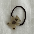 Détail de l'élastique à cheveux ours en résine marron clair avec cœur sur lin blanc - Élastique à Cheveux Café Transparent