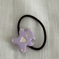 Détail d'un chouchou ourson violet en résine avec cœur sur tissu texturé blanc - Violet Élastique à Cheveux
