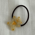 Vue détaillée d'un adorable ourson en résine beige sur un élastique à cheveux noir - Élastique à Cheveux Jaune Transparent