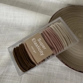 Makroaufnahme von 50 elastischen Haargummis in Erdtönen in einer transparenten Box - Kaffee-Rosa