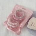 Close-up of pink gradient spiral hair coils in a cute translucent zipper storage bag - Pink