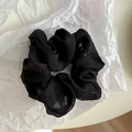 Macro detail of high-elastic black organza mesh scrunchie texture and delicate fabric pleats - Black