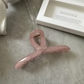 Detail shot of a pink translucent ribbon-shaped hair claw clip on a stone texture background - Korean Pink