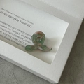 Détail d'une mini pince à cheveux en acétate avec marbrures vert-rose et ressort doré - Vert Floral
