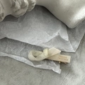 Detail of cream white marble-textured hair clip with gold metal base and handmade engraving - White