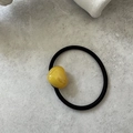 Close-up of black elastic hair tie with a yellow heart pendant and French text - Yellow