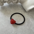 Macro shot of red heart acrylic hair tie with gold Barrette La France text and black band - Red