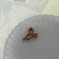 Détail d'une mini pince à cheveux en forme de nœud marron brillant pour coiffure chic - Marron