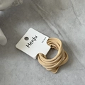 Detail view of high-elasticity khaki hair bands on display card over marble surface - Yellow