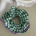 Detalle del coletero de cuadros verdes con borde de tela púrpura en fondo minimalista - Cuadros Verdes Con Borde Púrpura