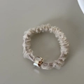 Detail showing sheer champagne organza scrunchie with a square crystal bead accent - Apricot