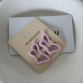 Close-up of two pink butterfly metal hair clips on a handmade accessories display card - Light Pink