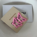 Close-up of two pink butterfly hair clips with wave-edged metal cutout and glossy finish - Deep Pink