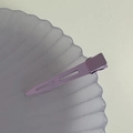 Close-up of lavender matte metal hair clip on a decorative purple wave tray - Purple