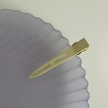 Detail of gold metal crease-free hair clip with hollow design on a purple shell tray - Yellow