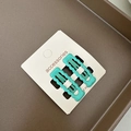 Détail de deux pinces à cheveux ondulées vert menthe sur une carte d'affichage - Cyan