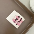 Dettaglio di due fermagli per capelli rosa opaco con bordi ondulati su cartoncino - Rosa Intenso