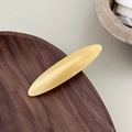 Détail d'une barrette ovale en acétate jaune crème avec l'inscription Barrette La France - Jaune