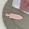 Detail shot of wavy pink non-marking hair clip on a decorative tray with card - Pink