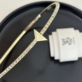 Macro view of gold metal headband with lucky triangle charm and pavé crystals - Triangle Rhinestone Headband / Gold