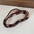 Detail of tortoiseshell resin hair claw clip with metallic spring and wavy grip design - Brown