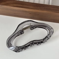 Dettaglio del fermaglio per capelli ondulato in resina grigio fumo con molla in metallo - Grigio