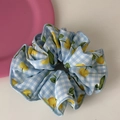 Dettaglio di scrunchie a quadretti blu e bianchi con stampa di frutta gialla e cuciture - Stile Ciliegia Blu