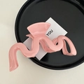 Makro-Detail einer großen rosa gewellten Haarklammer auf einem stilvollen Präsentierteller - Wellig Rosa