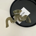Macro detail of large translucent dark green wave hair claw clip on elegant display - Wavy Green