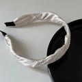 Detailansicht des gewellten champagnerfarbenen Satin-Haarreifs mit Perlen und Endschutz - Beige