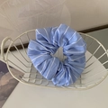 Dettaglio di un elastico in tessuto a righe bianche e blu in un cesto di metallo bianco - Righe blu e bianche
