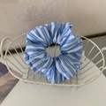 Dettaglio di un elastico per capelli in tessuto a righe bianche e blu in un cesto bianco - Base Bianca Striscia Blu Chiaro