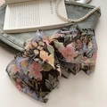 Macro view of floral multilayer oversized bow hair clip on denim with pearls - Higambana Floral