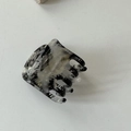 Détail d'une pince à cheveux en acétate à motif marbre avec gravure du logo MY BEAR - Noir et Blanc