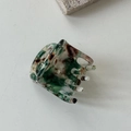 Détail d'une pince à cheveux en acétate marbré avec lettrage doré BEAR stylisé - Vert foncé