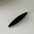 Detail einer glatten schwarzen Haarspange mit goldener Aufschrift und glänzendem Finish - Schwarz