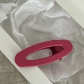 Detalle de una pinza para el pelo ovalada hueca magenta mate sobre fondo blanco - Rosa Roja