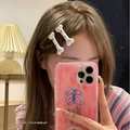 Détail de deux pinces à cheveux blanches en forme d'os avec étoiles colorées sur un modèle - Paire d'Os Y2K - Blanc