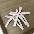 Primer plano de pinzas para el cabello con lazo de seda rosa en madera oscura - Rosa