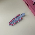 Makro-Detail einer lila Metall-Haarklammer mit rosa Schleifen-Webmuster-Design - Gewebter Spurloser Clip-Lila