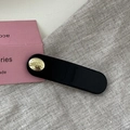 Detail of matte black hair clip with a gold 'Believe in Yourself' circular charm - Oval Gold Button BB-Black