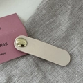 Detail of beige oval acetate hair clip with a gold button engraved with believe in yourself - Oval Gold Button BB-Cream White