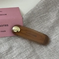 Macro detail of brown acetate hair clip with golden metal buckle and engraved text - Oval Gold Button BB-Coffee
