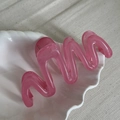 Detailed view of the pink translucent wavy claw clip inside a white shell dish - Transparent Pink