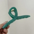Dettaglio dei denti e della molla dorata di una grande clip per capelli verde opaco - Verde Menta